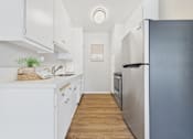 Thumbnail 2 of 36 - A kitchen with white cabinets and a black refrigerator.