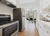 Thumbnail 1 of 36 - A modern kitchen with a black stove top oven and a white refrigerator.