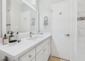 Thumbnail 12 of 36 - A white bathroom with a marble wall and a white sink.