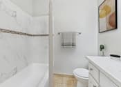 Thumbnail 13 of 36 - A bathroom with a marble wall and a white bathtub.