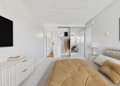 Thumbnail 9 of 36 - A bedroom with a large bed and a wardrobe in the background.