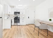 Thumbnail 20 of 32 - A modern kitchen with a dining table and chairs.