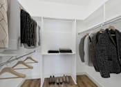 Thumbnail 9 of 16 - A white closet with clothes and shoes.