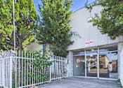 Thumbnail 31 of 33 - A white fence surrounds a building with a red sign that reads "EXIT".