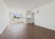 Thumbnail 25 of 33 - Empty room with white walls and wooden floor.