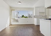 Thumbnail 24 of 33 - A kitchen with white cabinets and a window overlooking a street.