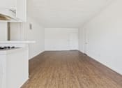 Thumbnail 26 of 33 - A room with wooden floors and white walls.