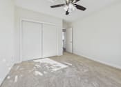 Thumbnail 28 of 33 - A room with a ceiling fan and two white doors.