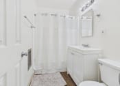 Thumbnail 29 of 33 - A white bathroom with a toilet, sink, and shower.