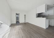 Thumbnail 14 of 33 - A kitchen with white cabinets and a wooden floor.