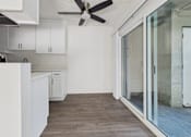 Thumbnail 13 of 33 - A modern kitchen with white cabinets and a ceiling fan.