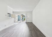 Thumbnail 15 of 33 - A long, empty hallway with wood flooring and white walls.