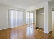 Thumbnail 18 of 35 - A room with a wooden floor and a sliding door.