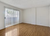 Thumbnail 20 of 35 - Empty room with wooden floor and white walls.