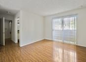 Thumbnail 21 of 35 - A room with wooden floors and a sliding glass door.