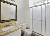 Thumbnail 22 of 35 - A bathroom with a toilet, sink, and shower.
