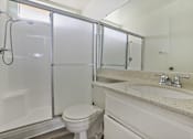 Thumbnail 26 of 35 - A white toilet sits next to a sink in a bathroom.