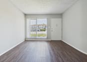 Thumbnail 29 of 75 - A room with a white door and a window with a view of a fence and a building outside.