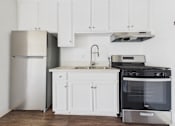 Thumbnail 23 of 75 - A kitchen with white cabinets and a stainless steel refrigerator.