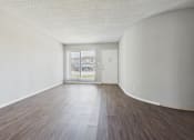 Thumbnail 28 of 75 - A room with a wooden floor and a white door.