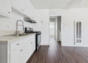Thumbnail 24 of 75 - A kitchen with white cabinets and a black stove top oven.
