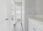 Thumbnail 39 of 75 - A white hallway with a wooden floor and white walls.