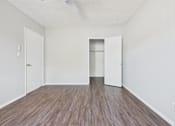 Thumbnail 36 of 75 - A room with a wooden floor and two white doors.