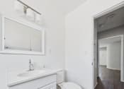 Thumbnail 41 of 75 - A white bathroom with a toilet, sink, and mirror.
