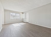 Thumbnail 50 of 75 - Empty room with light wood flooring and white walls.