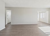 Thumbnail 47 of 75 - A spacious room with wooden flooring and white walls.