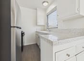 Thumbnail 44 of 75 - A kitchen with a refrigerator, sink, and cabinets.