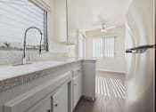 Thumbnail 43 of 75 - A kitchen with a granite countertop and a stainless steel refrigerator.