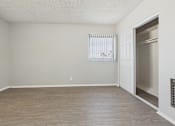 Thumbnail 53 of 75 - A room with a wooden floor and a window with blinds.
