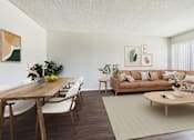 Thumbnail 12 of 91 - A living room with a brown wooden table and white chairs.