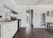 Thumbnail 9 of 91 - A kitchen with white cabinets and a black stove top oven.
