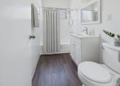 Thumbnail 16 of 91 - A white bathroom with a toilet, sink, and shower.