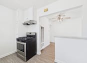 Thumbnail 31 of 38 - A black stove in a white kitchen with a fan on the ceiling.