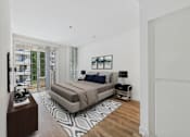Thumbnail 5 of 16 - A bedroom with a large bed and a balcony with a view of a building.