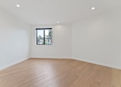 Thumbnail 102 of 119 - Empty room with wooden floor and a window.