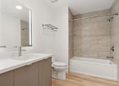 Thumbnail 129 of 163 - A white bathroom with a toilet, sink, and bathtub.