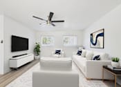 Thumbnail 13 of 41 - A living room with a white couch, a television, and a ceiling fan.
