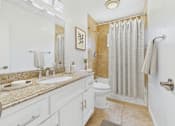 Thumbnail 10 of 41 - A bathroom with a sink, mirror, toilet, and shower.