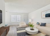 Thumbnail 5 of 72 - A living room with a white couch, a round coffee table, and a painting on the wall.