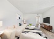Thumbnail 4 of 72 - A living room with a white couch, a white coffee table, and a black and white striped rug.