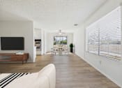 Thumbnail 2 of 72 - A living room with a white couch and a television.