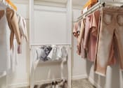 Thumbnail 14 of 70 - a closet with clothes hanging on a rack and a white closet door
