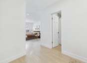 Thumbnail 5 of 95 - A white door is open to a room with a bed and a table.