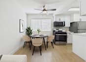 Thumbnail 12 of 95 - A modern kitchen with a dining table and chairs.