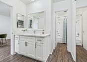 Thumbnail 29 of 95 - A white bathroom with a green chair and a wooden floor.