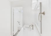 Thumbnail 35 of 81 - A white bathroom with a sink and mirror.